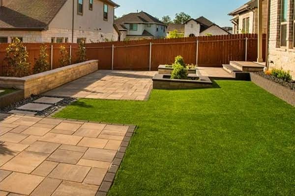Neatly maintained back garden with lawn, patio and planted borders