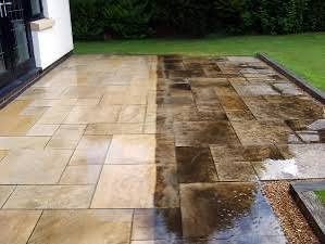 Patio slabs half cleaned, showing the before and after contrast of power washing