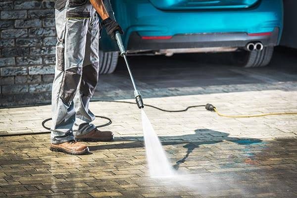 Pressure washing lifting years of grime off a driveway