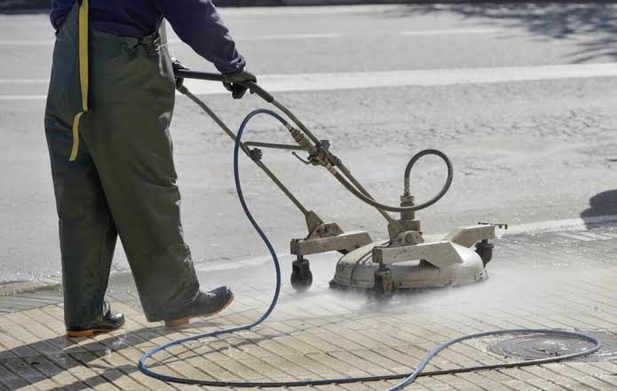 Pressure washing a paved pathway back to its original colour
